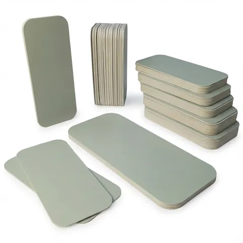 Long rectangular silver-grey board lids with rounded corners, shown loose, standing on end and in stacks, foil container, aluminium container