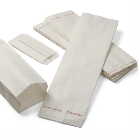 Long white greaseproof baguette bags with a small red 'Thank You' print, one opened out and others stacked flat, paper bag, grease proof bag