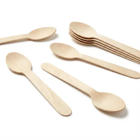 Natural birchwood dessert spoons with oval bowls and flat handles, some loose and some in a small stack, on a white background, wooden cutlery, birchwood cutlery