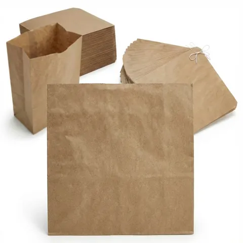 Brown kraft paper bags: one flat bag in front, one standing open, a flat stack and a bundle strung together through one corner, greaseproof bag, grease proof bag