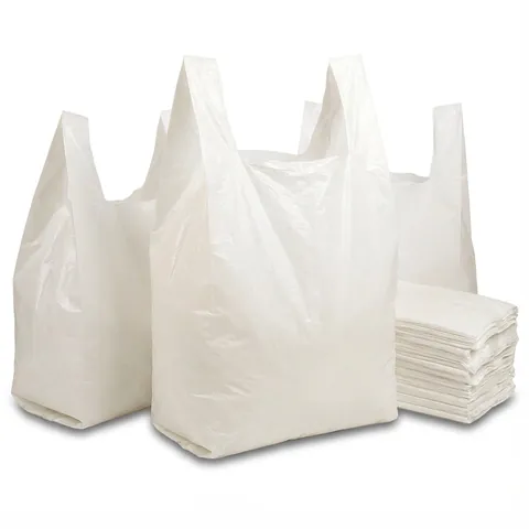 Three white plastic vest carrier bags standing open, with a stack of folded bags beside them, plastic bag, white carrier bag