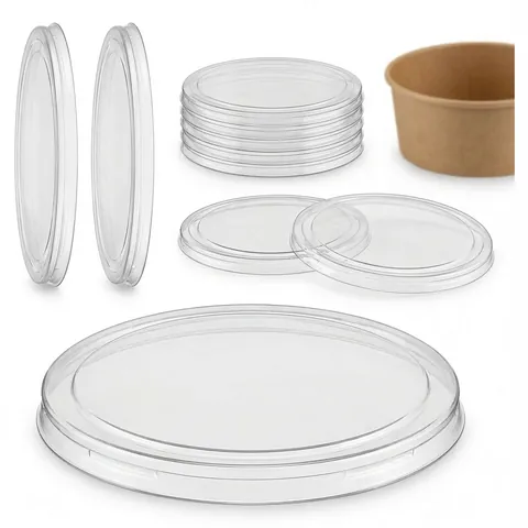 Clear flat round plastic lids, stacked and single, next to a kraft paper bowl, deli bowl, salad bowl