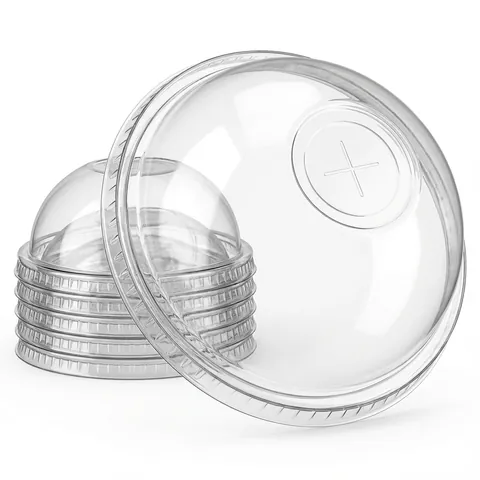 Clear plastic dome lids with a cross-cut straw hole, one lid on its edge in front of a stack, smoothie cup, milkshake cup