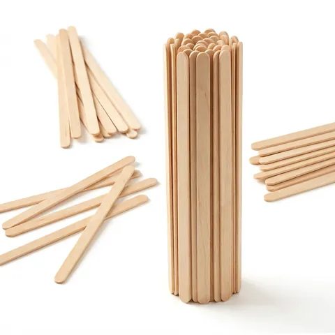 Natural wooden coffee stirrers with rounded ends, standing in a bundle and lying loose, coffee cup, paper cup